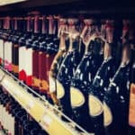 inquadratura laterale di bottiglie di vino su una scaffalatura tipica di enoteca